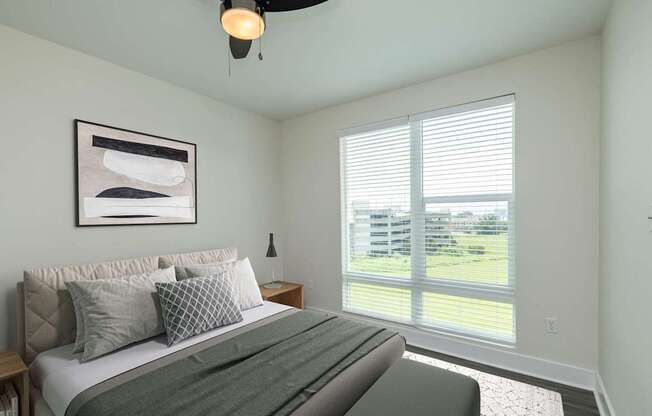 A bedroom with a large bed and a ceiling fan.