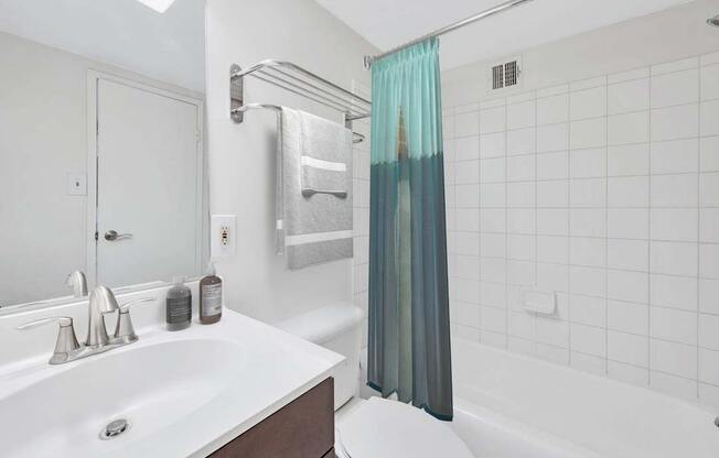 a white bathroom with a shower and a sink