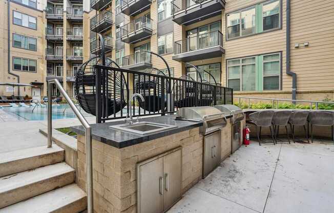 A patio with a hot tub and a black railing.