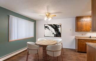 a dining room with a table and chairs and a ceiling fan. Fargo, ND Betty Ann Apartments