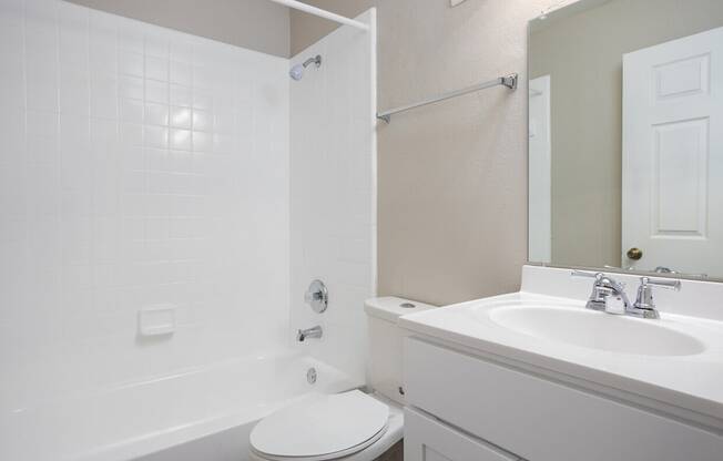 A white toilet sits next to a white sink in a bathroom.