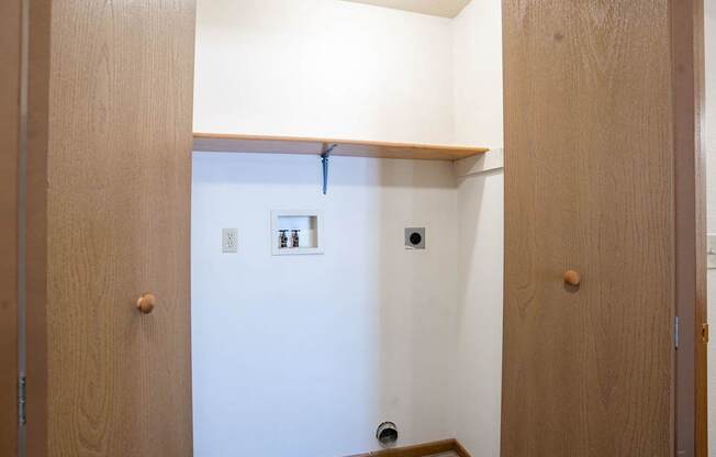 a closet with a shelf and laundry hookups. Fargo, ND Country Edge Apartments