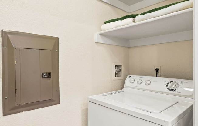 a white washer and dryer in a room with a dryer and shelf