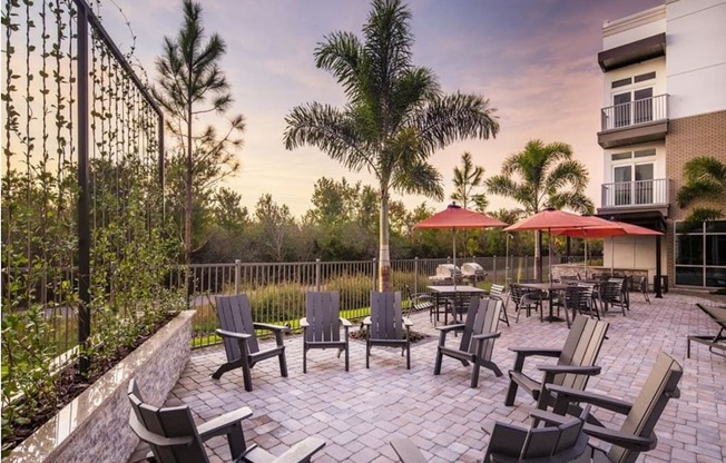 an outdoor patio with chairs and umbrellas at dusk