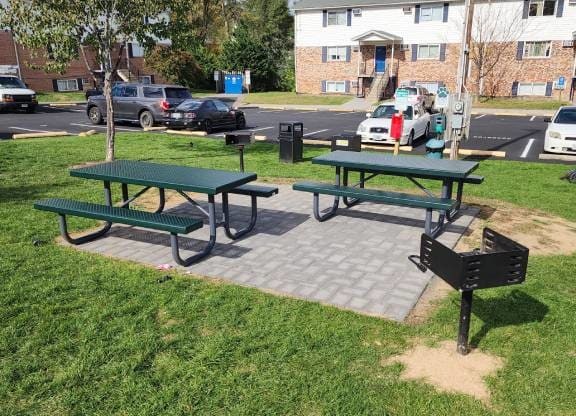 Picnic tables and benches are set up in a grassy area.