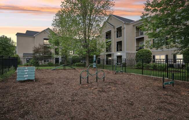 A playground with a swing set and a slide in front of apartment buildings.