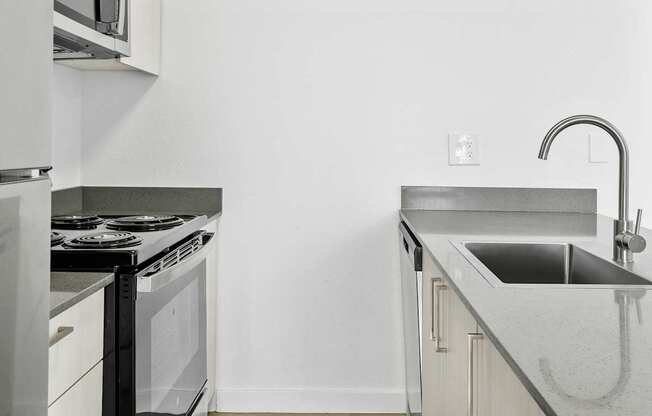 A modern kitchen with a stove and sink.