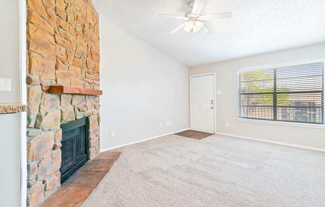 Carpeted Living Room at Terrace at Bookstone and Terrace Apartments in Irving, Texas