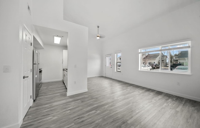 an empty room with a large window and white walls