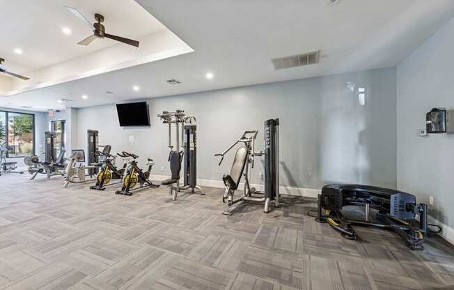 A spacious gym with a variety of equipment including treadmills, stationary bikes, and weight machines.