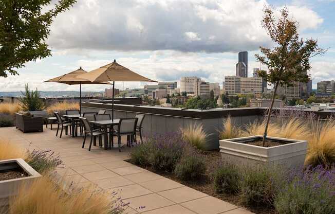 A patio with a table and chairs overlooking a city skyline.