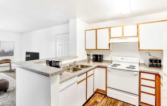 Model Kitchen with White Appliances, Grey Counters and White Cabinets with Wood Accents