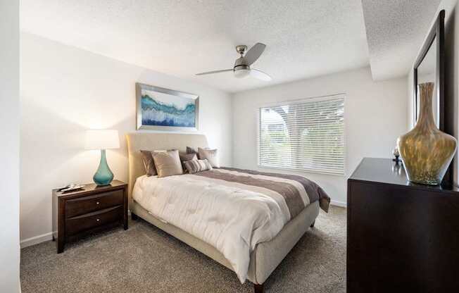 a bedroom with a bed and a ceiling fan