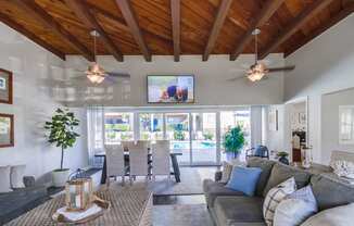 a living room with couches and chairs and a tv on the wall