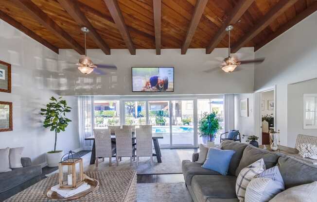 a living room with couches and chairs and a tv on the wall