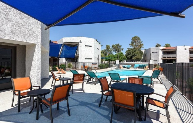 A patio with a table and chairs under a blue canopy.