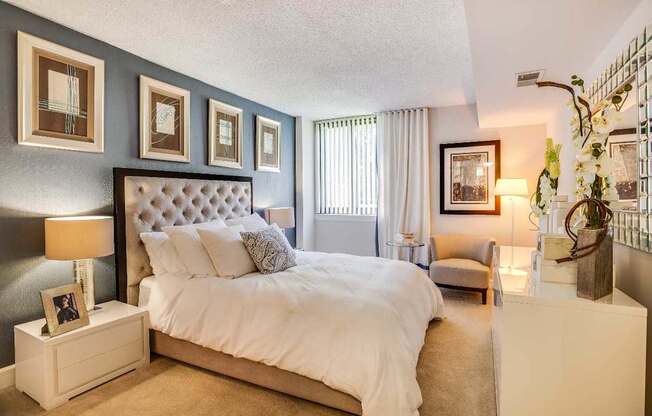 A bedroom with a large bed and a nightstand with a lamp.