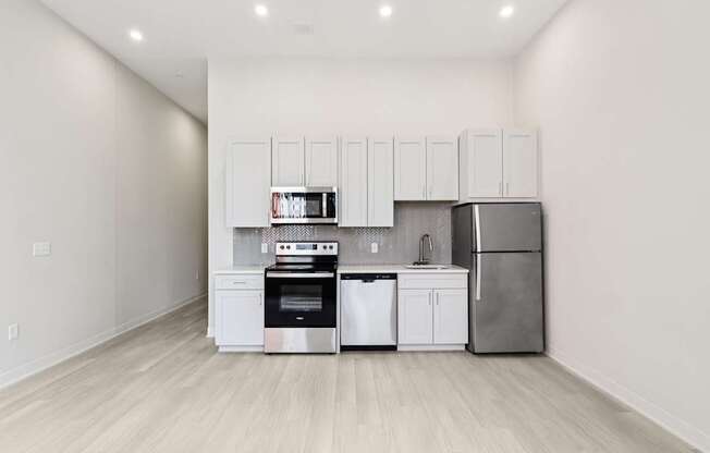 A kitchen with white cabinets and stainless steel appliances.