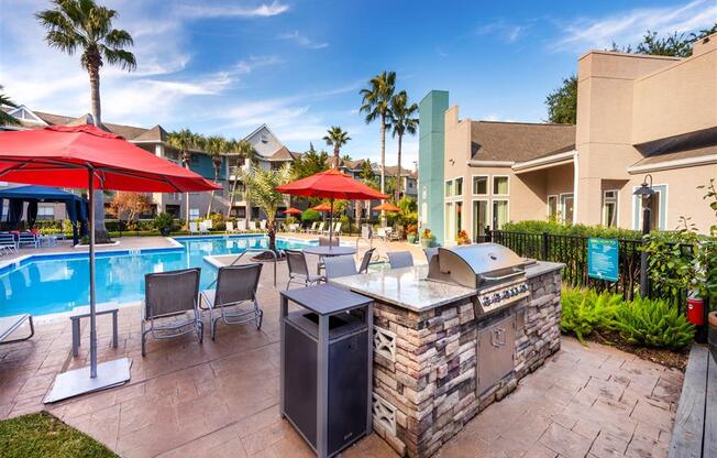 a resort style pool with a bar and tables with umbrellas