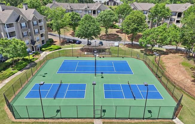 A tennis court  and pickleball courts with a gazebo next to them