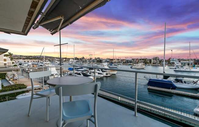 a balcony overlooking a marina with boats and a sunset