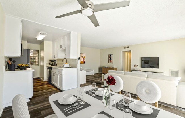 a living room and dining room with a table and a ceiling fan