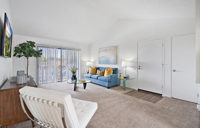 a living room with a blue couch and a white chair