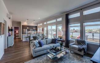 Lux Apartments Bellevue open living room and kitchen with breakfast bar, hard-wood styled flooring, and ample large windows with natural light.