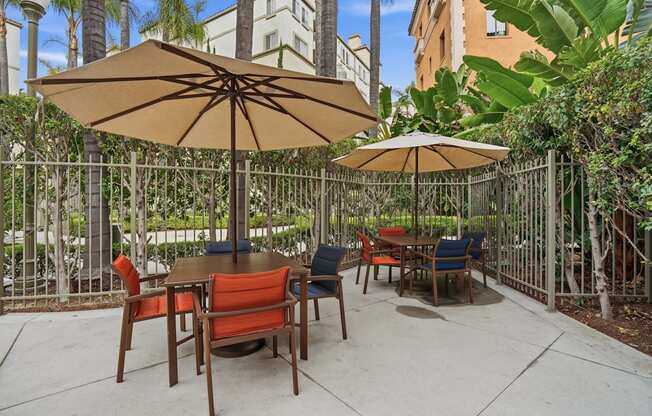A patio with a table and chairs under umbrellas.