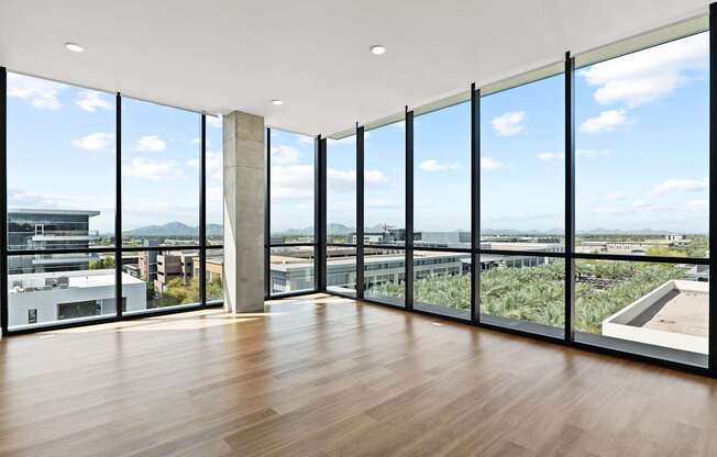 A room with a view of the city through large windows.