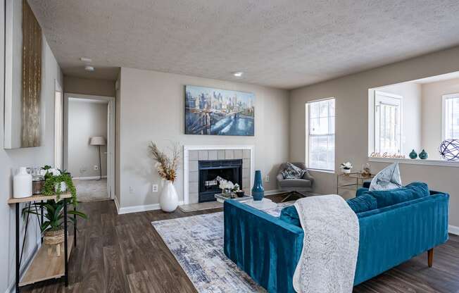 a living room with a blue couch and a fireplace