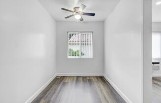 an empty room with a window and a ceiling fan