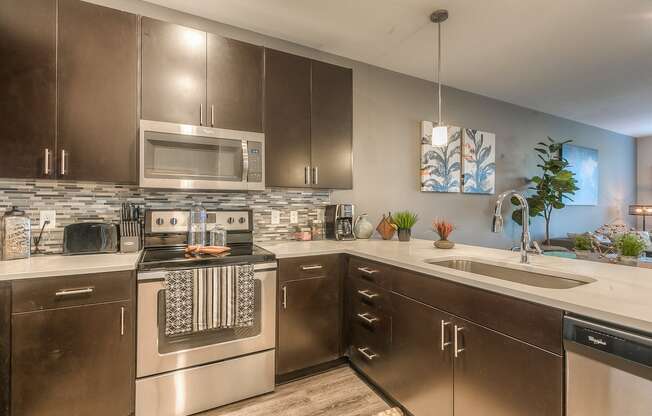 a kitchen with stainless steel appliances and white countertops