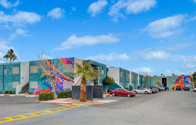 A wall with a colorful mural of a palm tree and a bird.