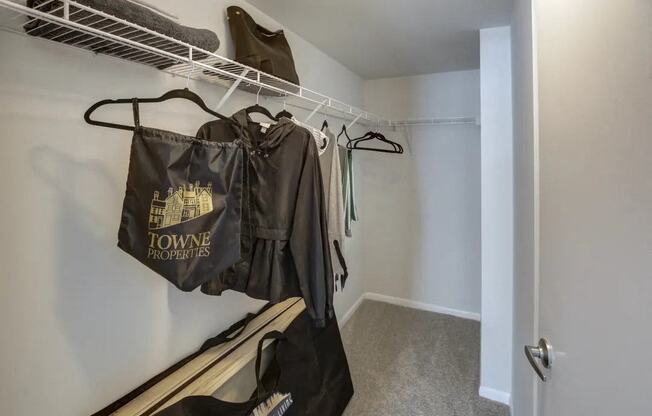 a walk in closet with clothes hanging on a rack in a home