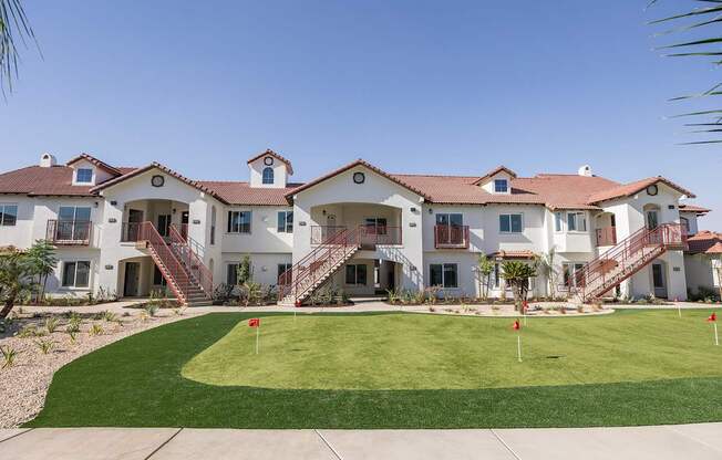 A row of houses with a green lawn in front.