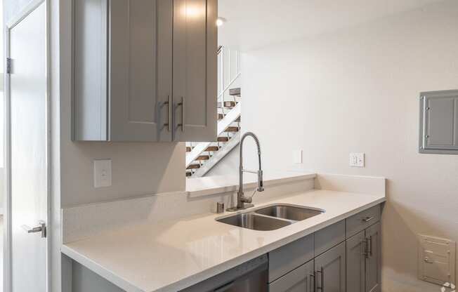 an empty kitchen with a sink and a staircase