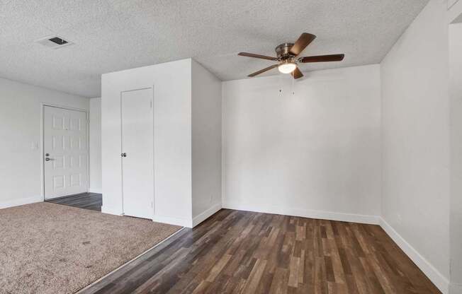 A room with a ceiling fan and two doors.