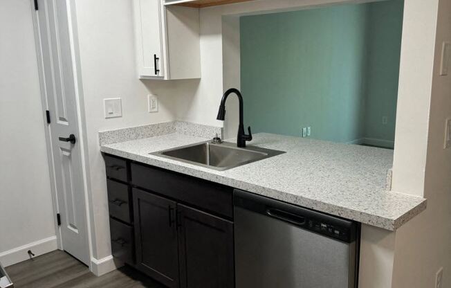 a kitchen with a sink and white cabinets