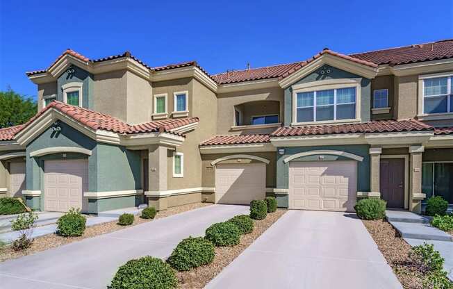 A row of houses with garages and driveways.