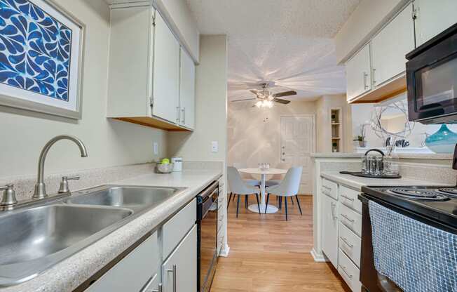 a kitchen with a sink and a stove and a dining room