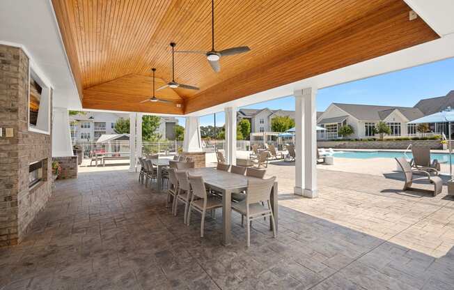 a dining area with tables and chairs next to a pool