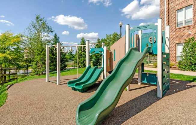 A playground with a green slide and a climbing frame.