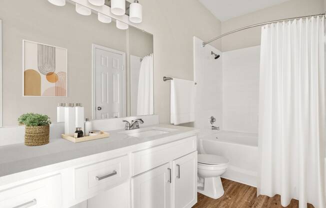 a white bathroom with a shower and a sink and a toilet