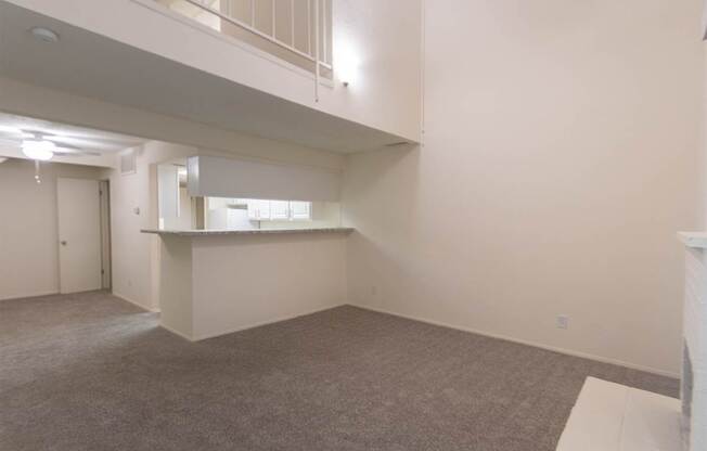 A living room with white brick fireplace in a 717 square foot 1 bedroom, 1 bath loft apartment home at Canyon Creek Apartments in Dallas Midtown neighborhood of Dallas, TX.