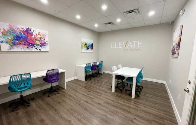 a room with a table and chairs and a sign that says elevate gyms on the wall