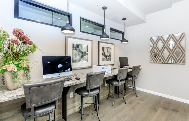 an office with a long desk with chairs and a computer