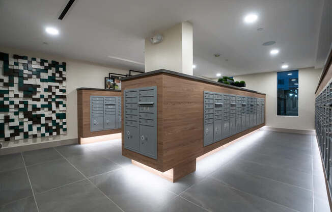 A modern office lobby with a wooden reception desk and a green plant on top.