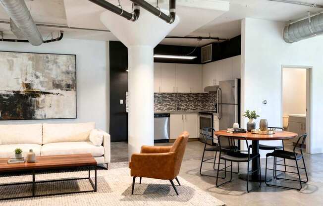 A modern living room with a large abstract painting on the wall.