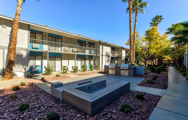 A modern building with a pool in the courtyard surrounded by palm trees.